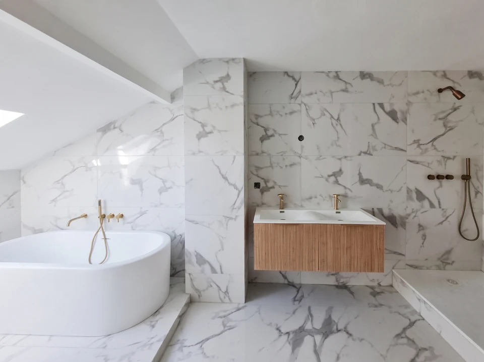 Salle de bain moderne rénovée avec baignoire-douche blanche, robinetterie chromée et carrelage métro blanc